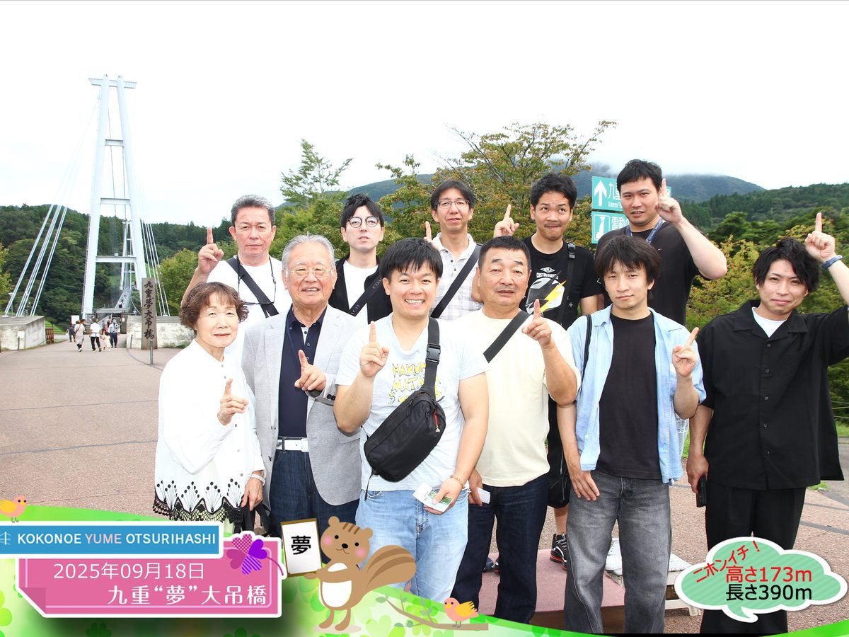 社員旅行での集合写真。九重夢大吊橋の前に社員が並んでいる